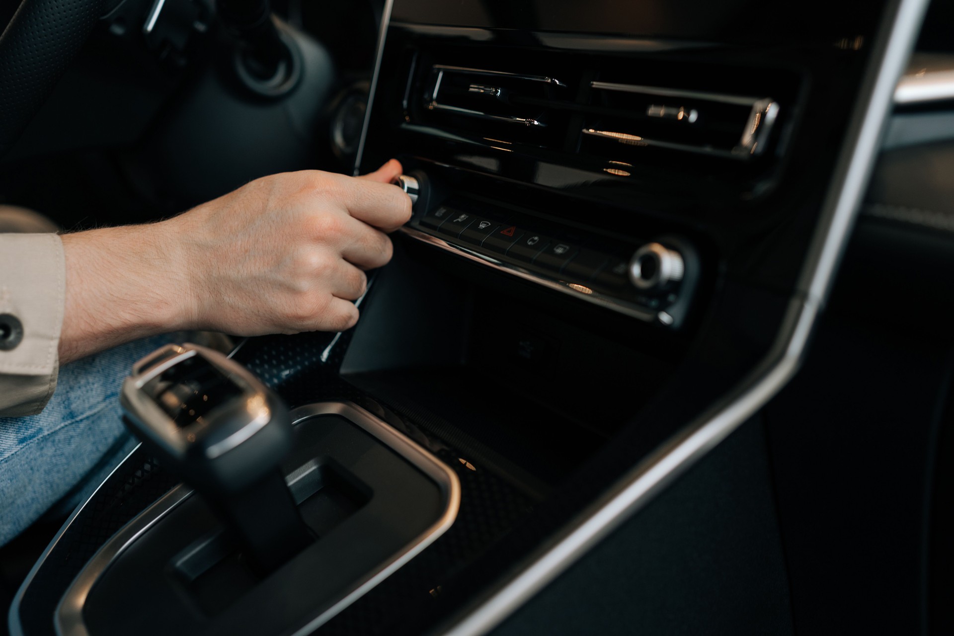 Closeup hands of driver male adjusting temperature in car by rotate. Close-up of man hand hold button of temperature. Close up of human hand rotating car temperature